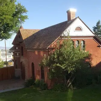 Historic red-brick building with a new shingle roof, arched windows and a white gable