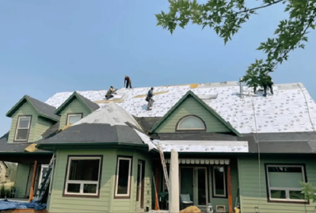 Crew installing underlayment on a green two-storey home